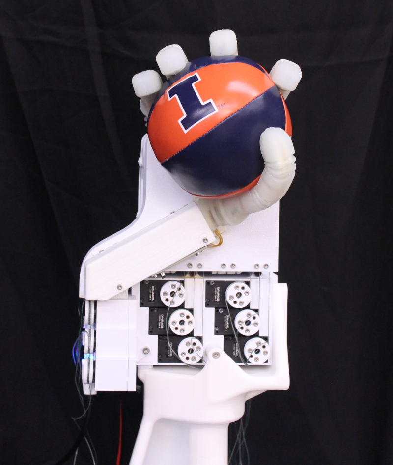 Image depicting a robotic hand holding an Illini orange and blue ball