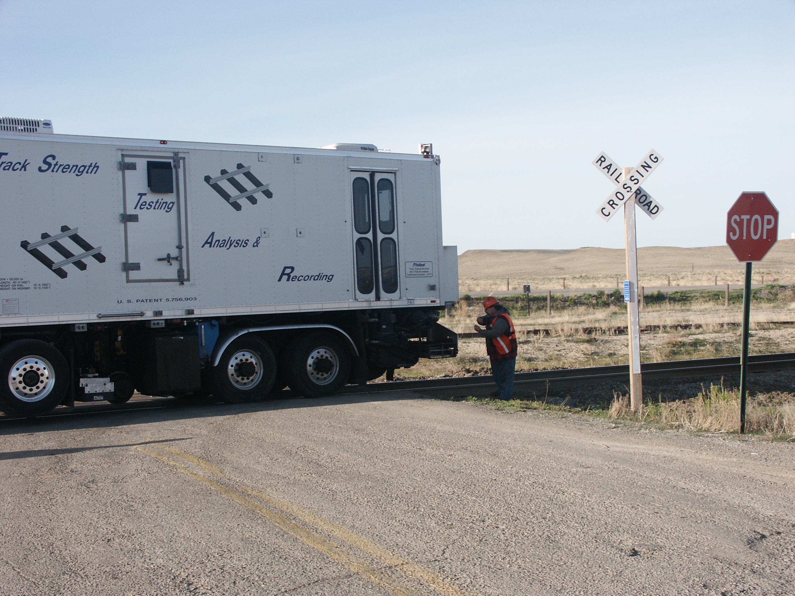 railroad track inspection truck with rail employee walking along railroad tracks