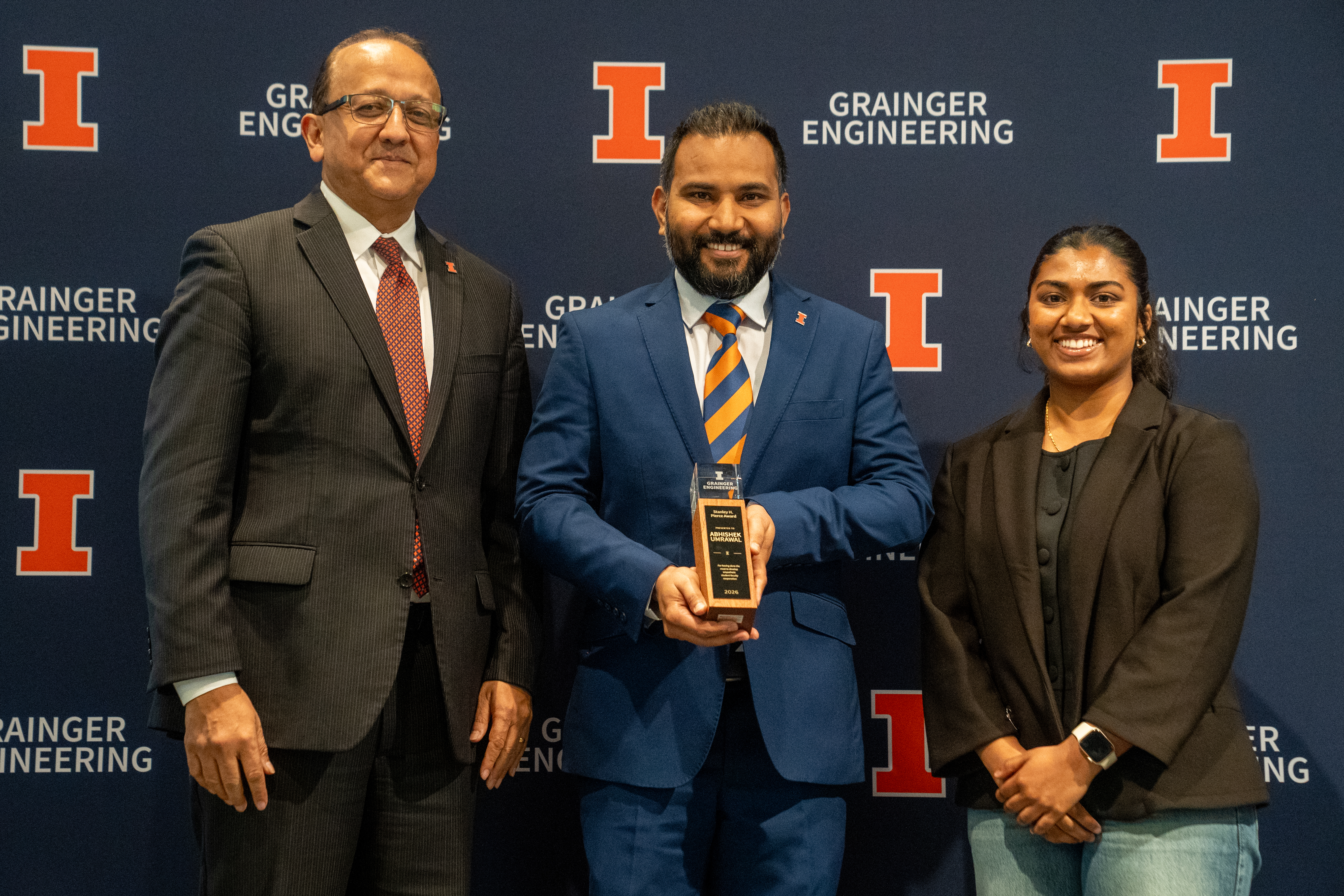 Teaching Assistant Professor Abhishek Umrawal holds the Stanley H. Pierce Faculty Award alongside Dean Rashid Bashir and a female