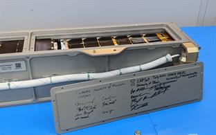 The Nanoracks CubeSat Deployer, which CAPSat was loaded into, has flown several missions in the past so the access panel has markings and signatures from the 2019 CubeSat SOCRATES, as well as the satellite that sits behind CAPSat for this launch, SPACE HAUC.&nbsp; The signatures of Logan Power and Rick Eason can be seen directly underneath the UIUC Block I sketch.