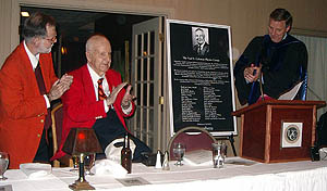 Susquehanna University President Jay Lemons (right) presents a poster image of the commemorative plaque that now adorns the Paul D. Coleman Physics Center at Susquehanna. Coleman and his son Peter look on at left.