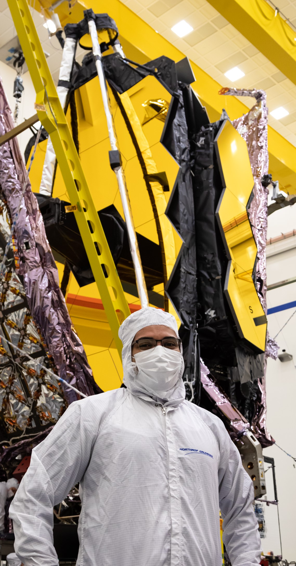 Nanavati and his team performed hundreds of hours of testing and verification on the telescope&mdash;some of which was performed in cleanrooms that simulated zero gravity. [photo of SN in front of the JWST in cleanroom gear]