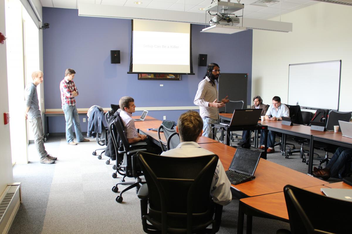 Members of Illinois' I-Corps Sites program listen as a team presents their progress on their research. Photo by Arjun Fadnis.