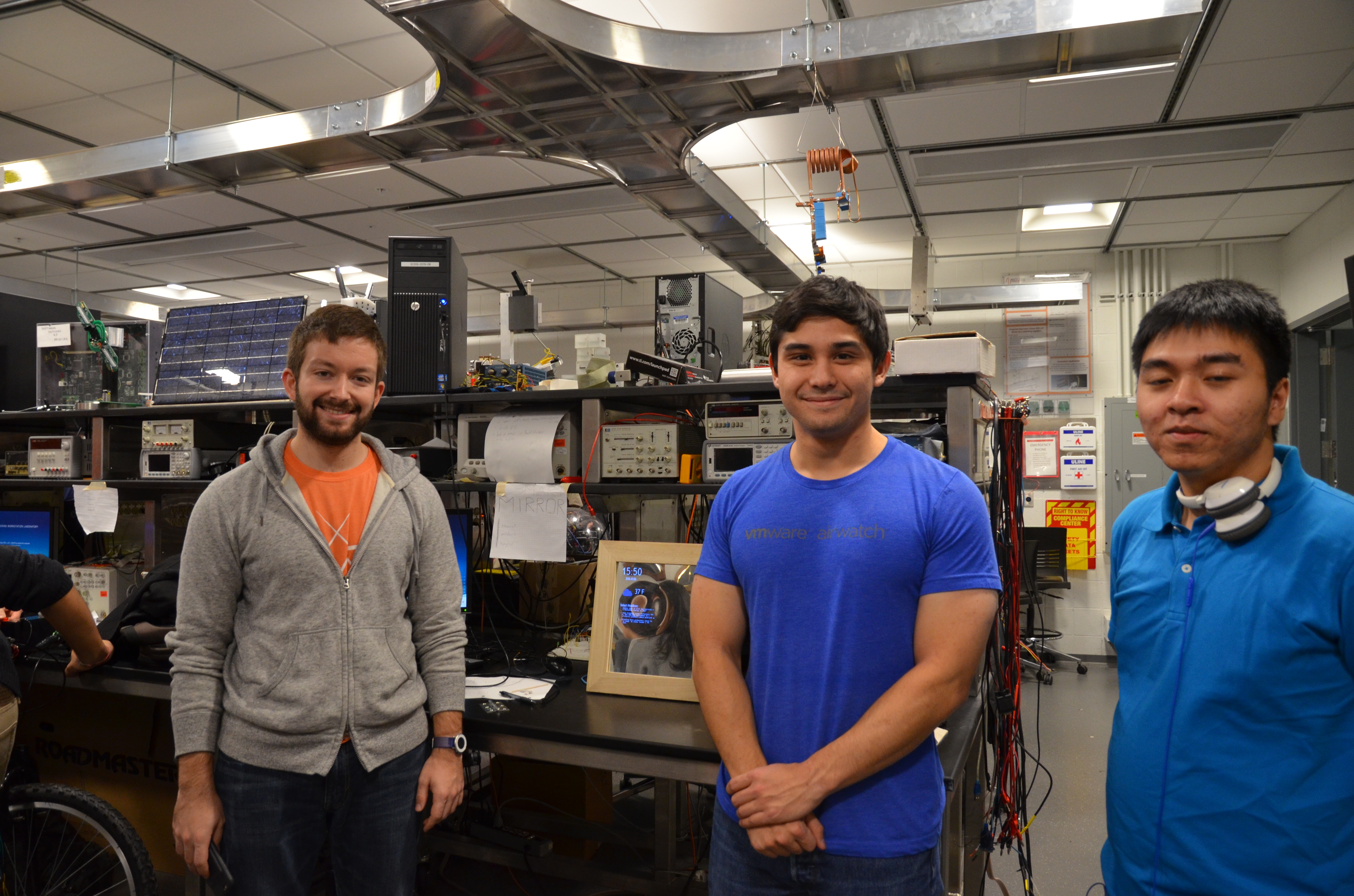 Vasil Pendavinji, Ben Moore, and Hung Le standing in front of their project the Smart Mirror.