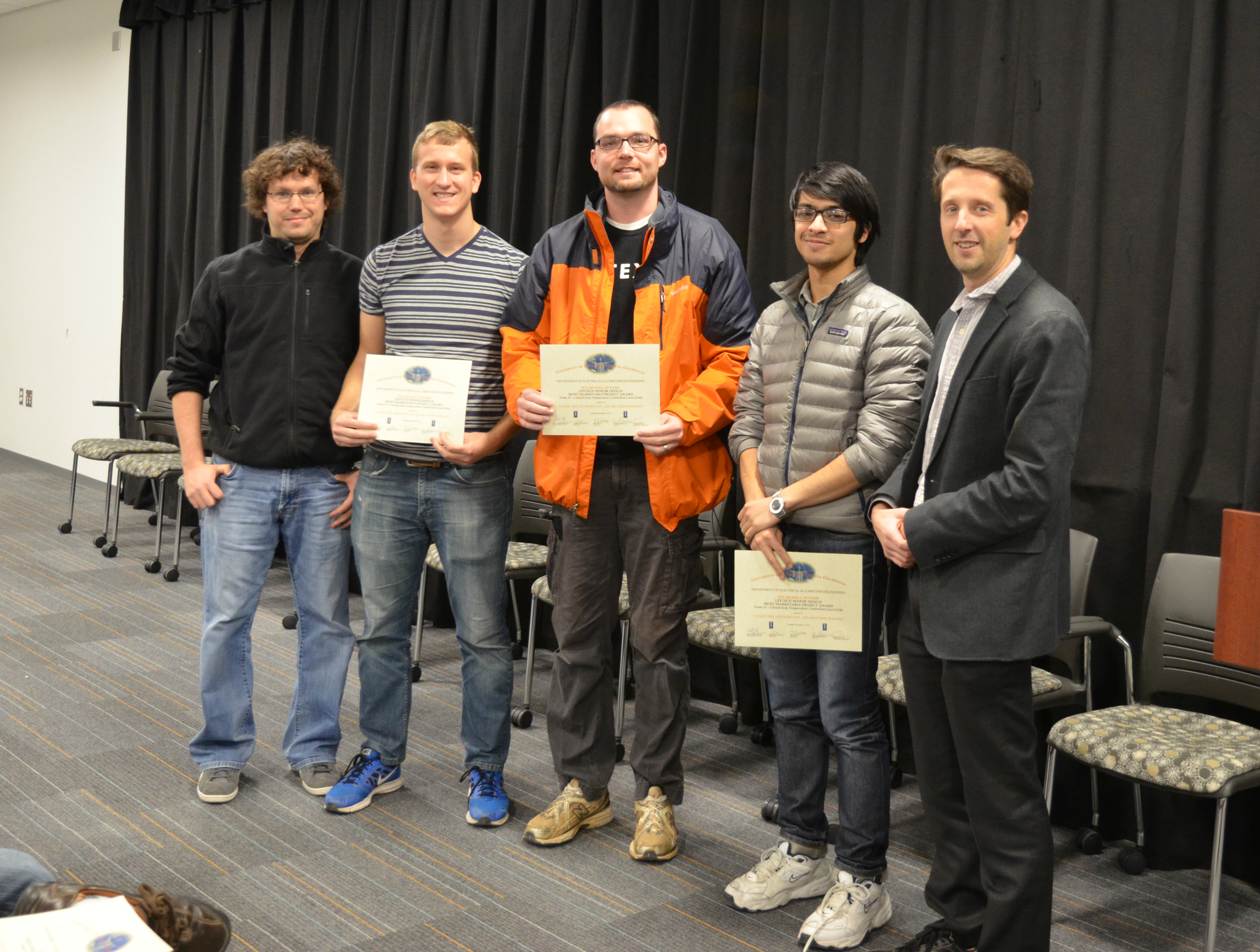 The Lextech Senior Design Most Marketable Project Award was presented to Team 13 for their 'Closed-loop Temperature Controlled Lava Globe.' Team members: Daniel Frei, Devin Bryant, and Matthew Romano. Also pictured: James Norton (TA) and Professor Makela.