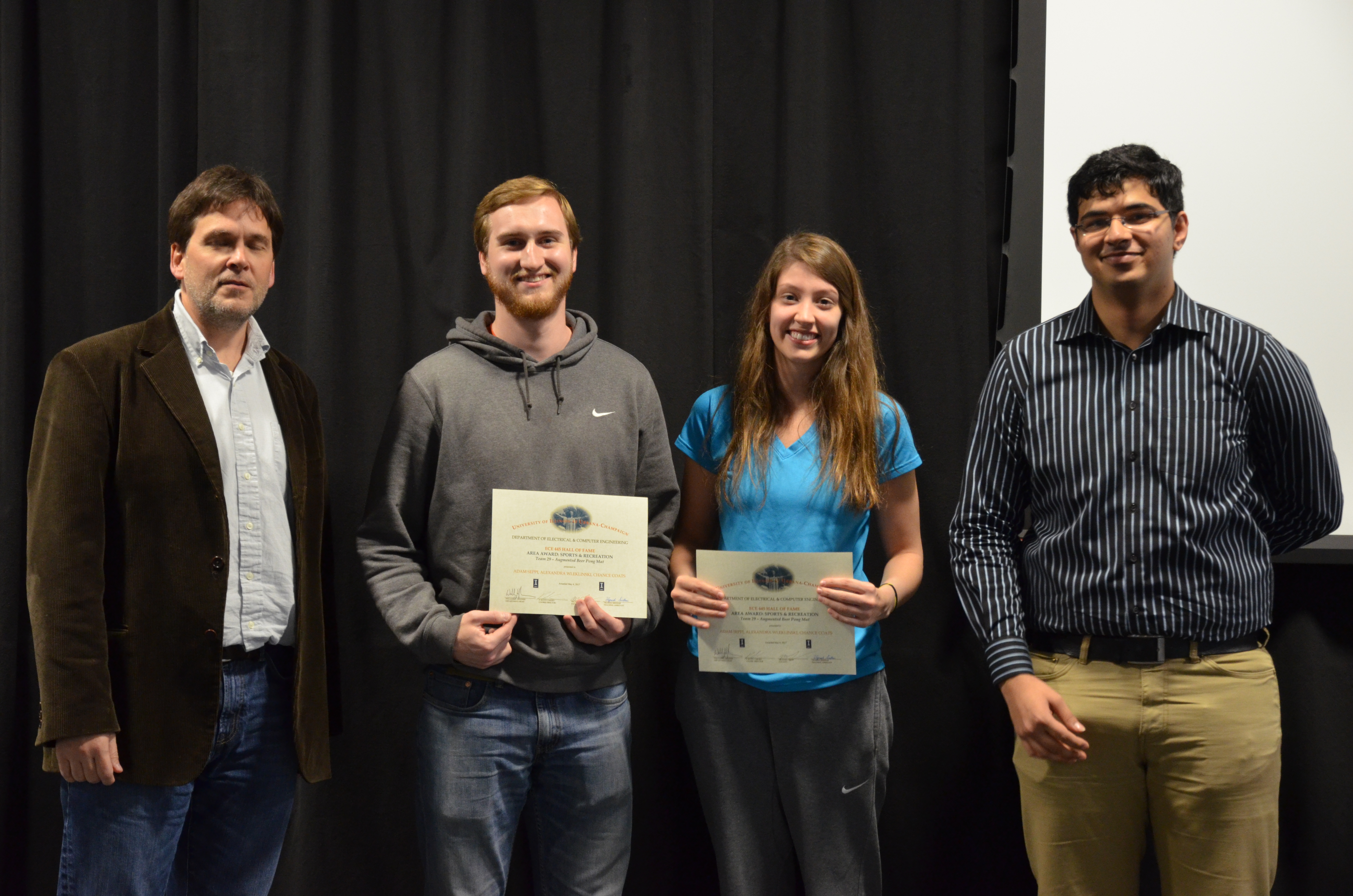 The Area Award for Sports and Recreation is presented to Adam Seppi, Alexandra Wleklinski and Chance Coats for their 'Augmented Beer Pong Mat.' Also pictured: Professor Oelze, Vignesh Sridhar (TA).