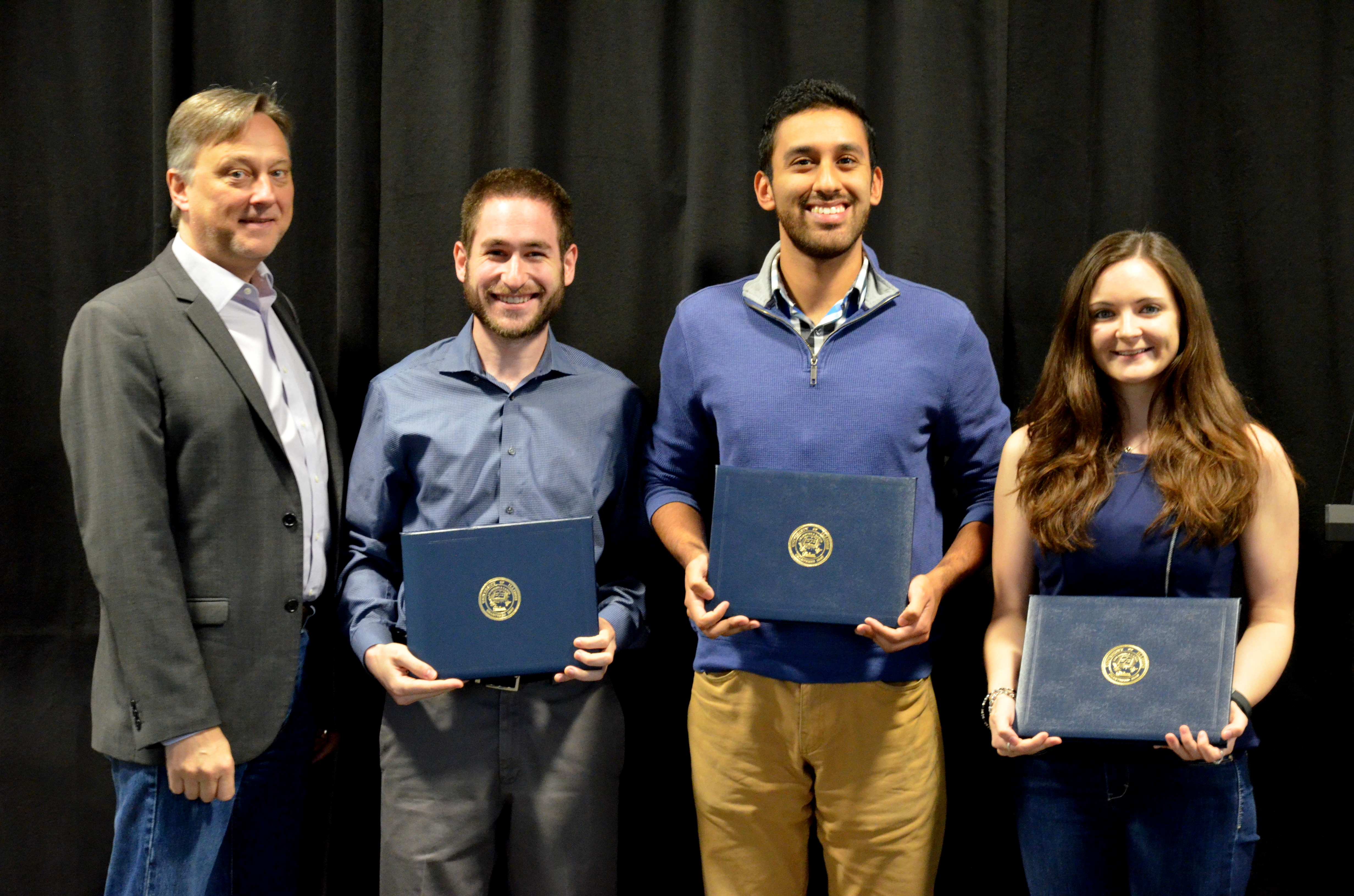 The LEXTECH Senior Design Most Marketable Project Award is presented to Mark Hafter, Omar Joya and Ellery Tomaszkiewicz  for their 'Collective Child Tracking System.' Also pictured: Professor Hutchinson.