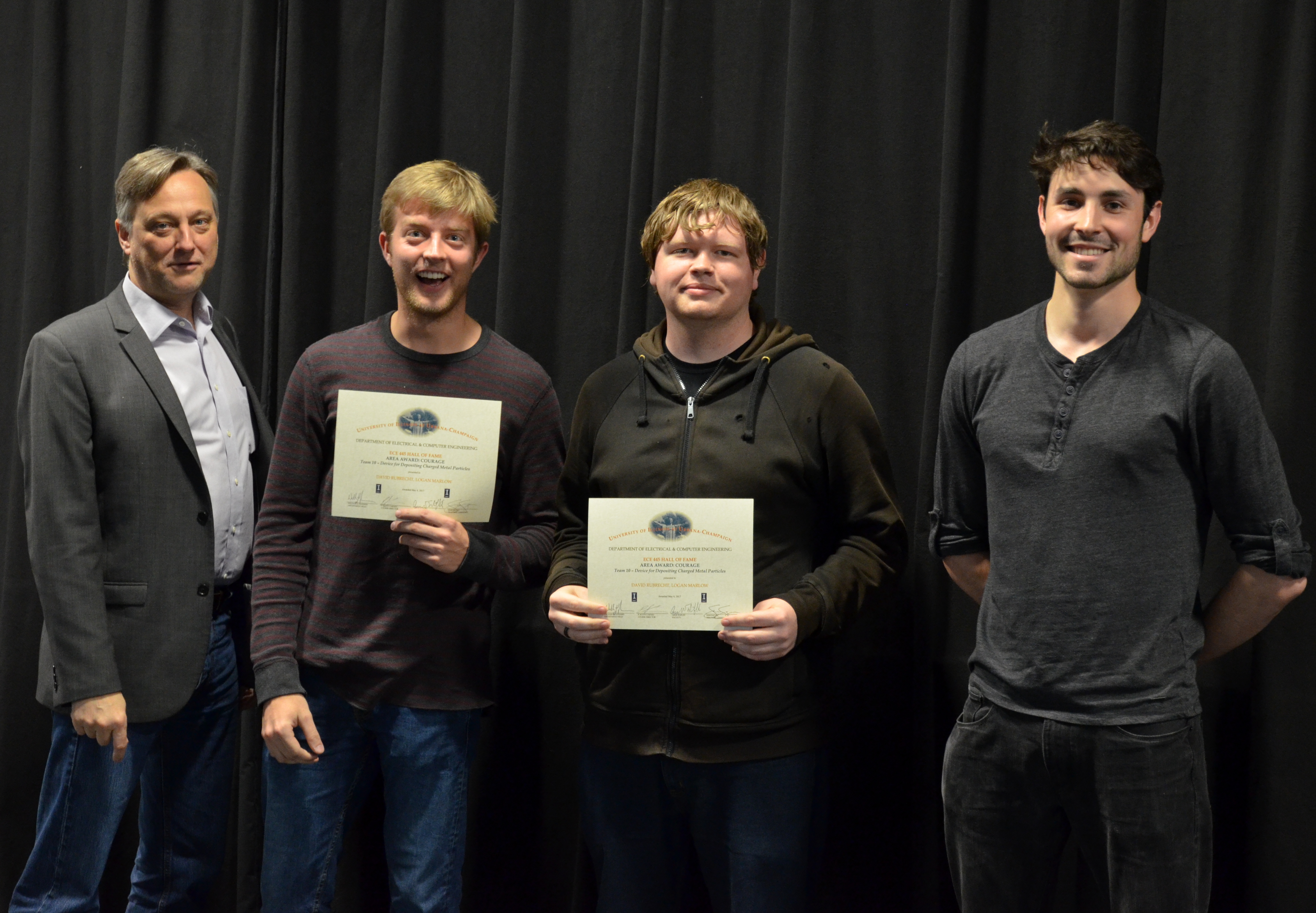 The Area Award for Courage is presented to David Rubrecth and Logan Marlow for their 'Device for Depositing Charged Metal Particles.' Also pictured: Professor Hutchinson, Sam Sagan (TA).