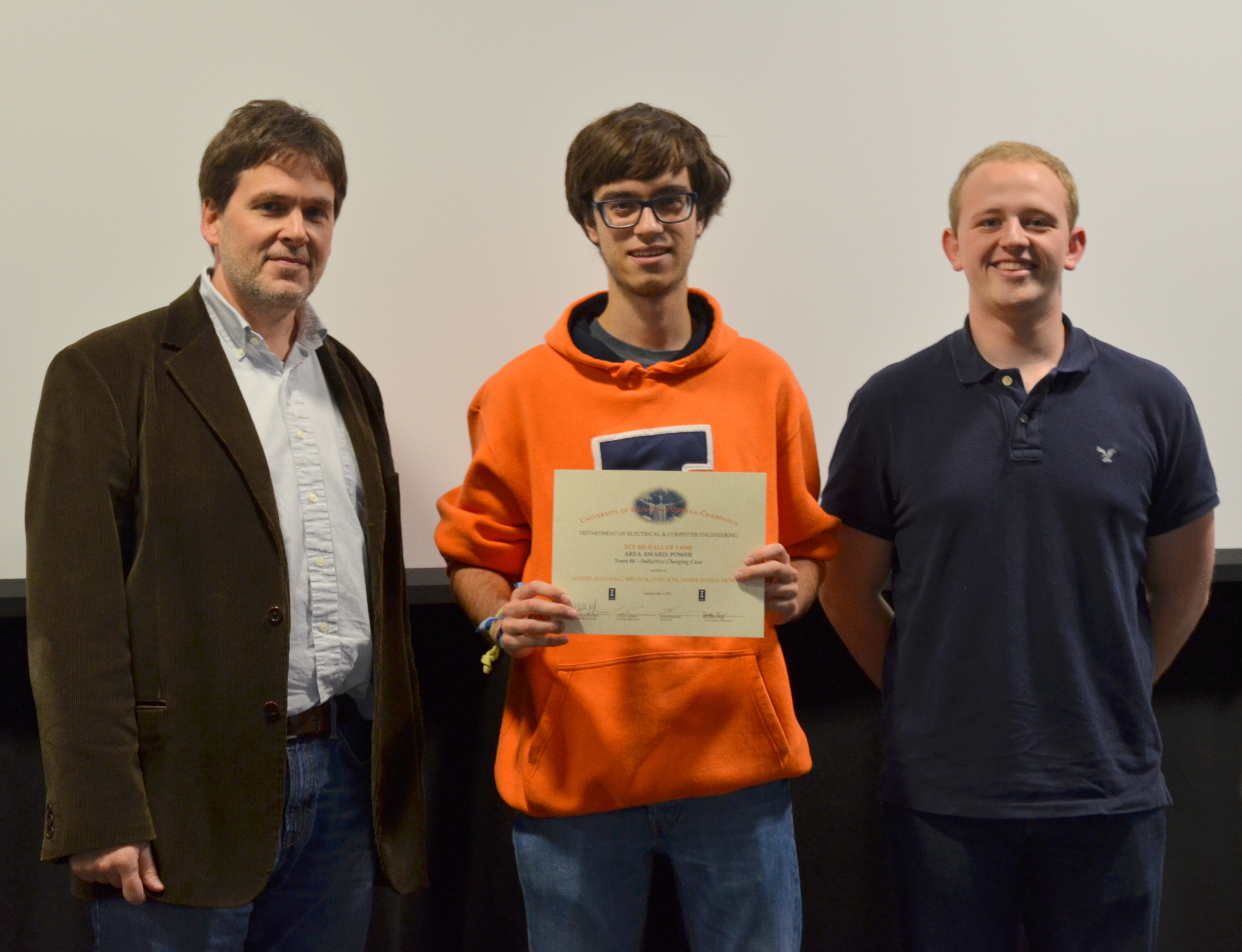 The Area Award for Power is awarded to Anshil Bhansali, Brain Slavin and Jose Montes for their 'Inductive Charging Case.' Also pictured: Professor Oelze, Jackson Lenz (TA).