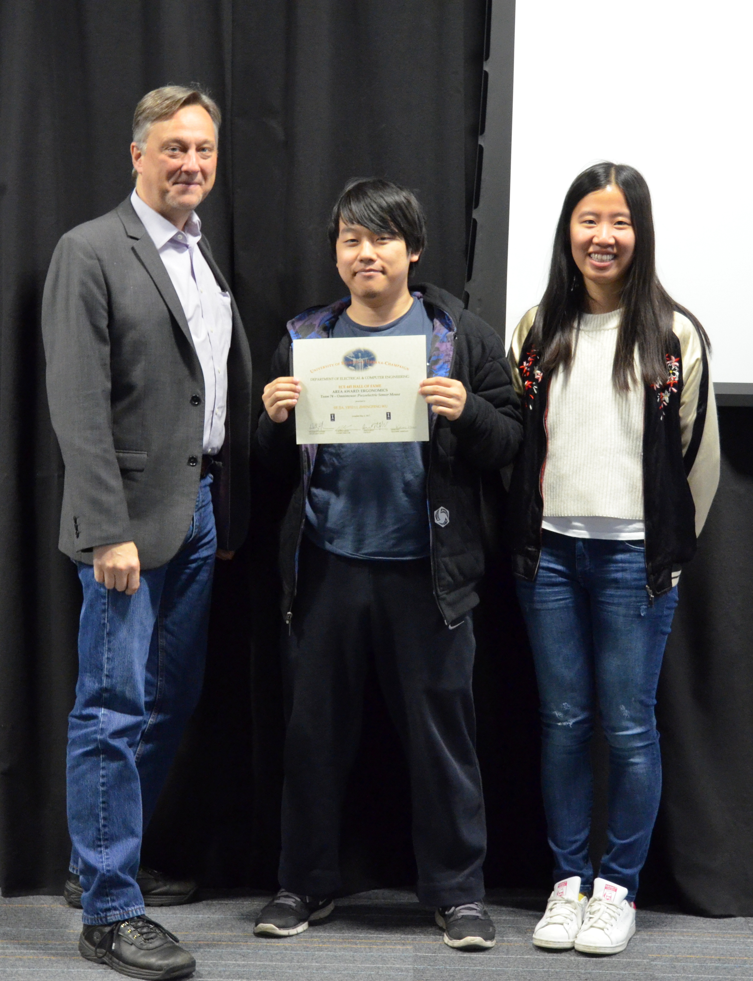 The Area Award for Ergonomics is presented to Jie Jia, Yifei Li and Zhengfeng Wu for their 'Omnimouse: Piezoelectric Sensor Mouse.' Also pictured: Professor Hutchinson, Kexin Hui (TA).