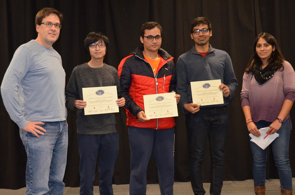 'RC Boat Power and Signal Level Indicator' won the Recreation and Entertainment Area Award. The team includes Sanchit Anand, Sho Harisawa, and Vaibhav Mittal. Professor Oelze and TA Yamuna Phal are also pictured.