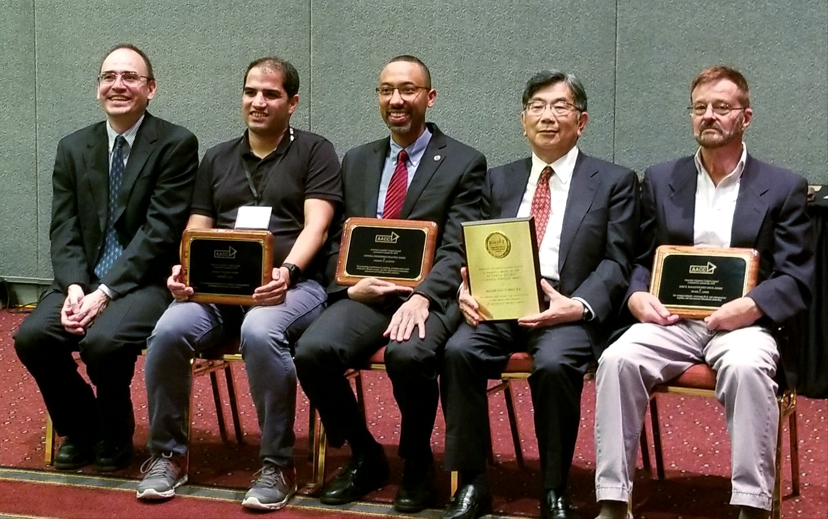 Alleyne, center, receives the award from AACC. 